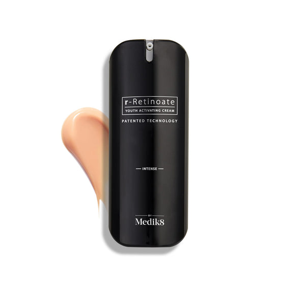Flacone di Medik8 r-Retinoate Intense Youth Activating Cream esposto su uno sfondo bianco, con una campionatura della crema color pesca visibile sullo sfondo.-36