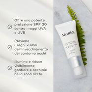 Tubo di crema contorno occhi Medik8 su sfondo in marmo con una foglia verde, con testo che ne spiega i benefici.