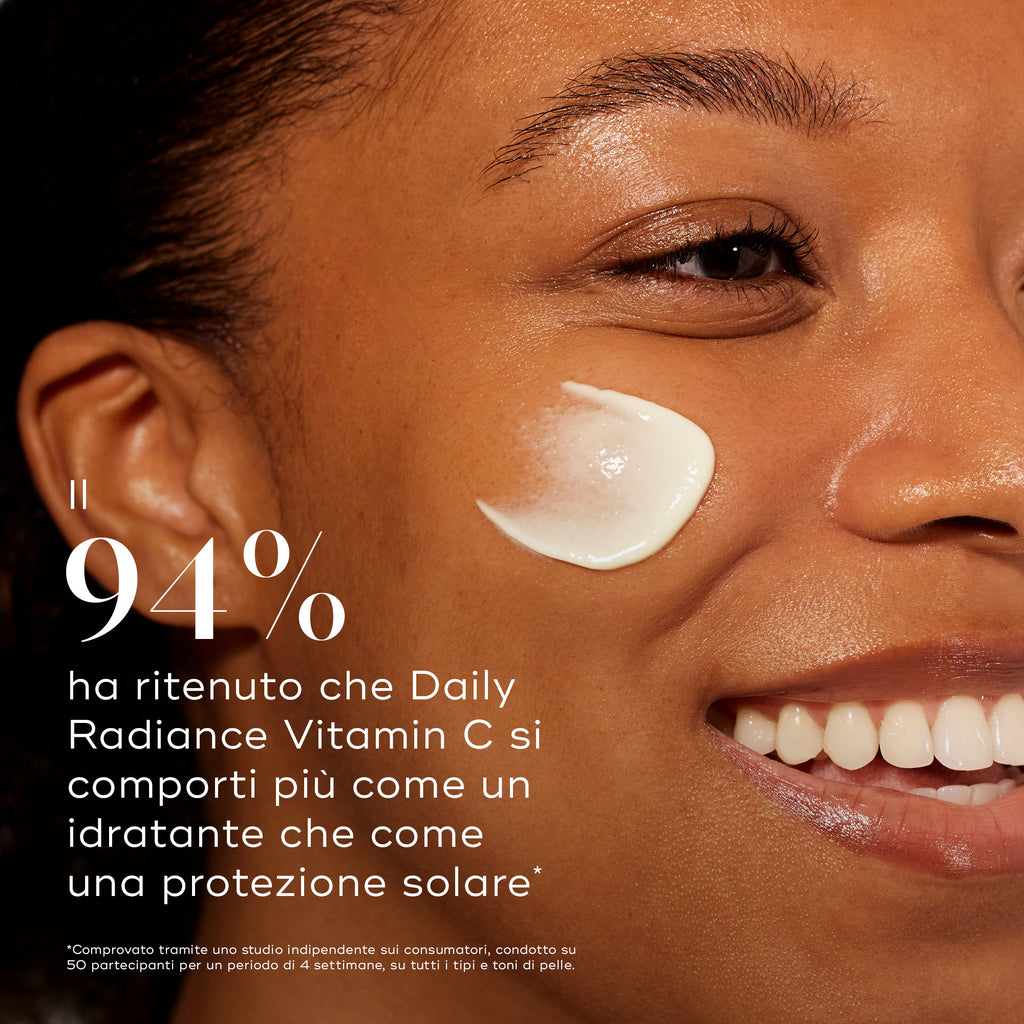Primo piano del volto di una donna con applicato un prodotto skincare, testo sulla principale caratteristica della Daily Radiance Vitamin C: il 94% ha percepito che si sente più come una crema idratante che come una protezione solare.