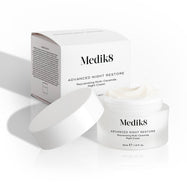 Il barattolo di Medik8 Advanced Night Restore è aperto, con il coperchio bianco appoggiato di lato e la confezione del prodotto sullo sfondo. L’immagine mette in evidenza la texture ricca della crema e il design pulito del packaging.