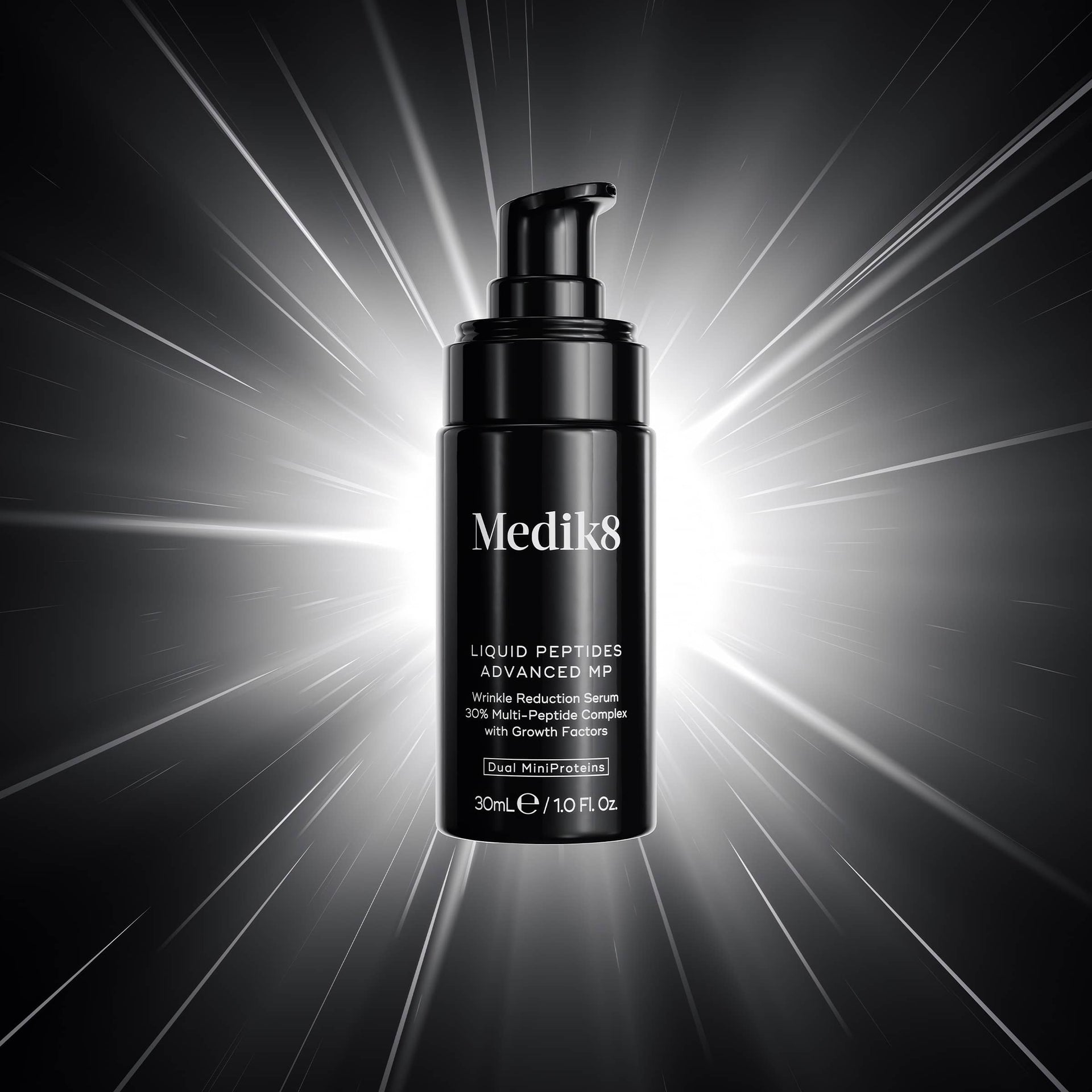 Medik8 Liquid Peptide Advanced MP bottle on a dark background with light radiating effects