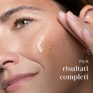 Primo piano di una donna che applica il siero Medik8 sulla guancia, con testo di riferimento ai risultati a spettro completo.